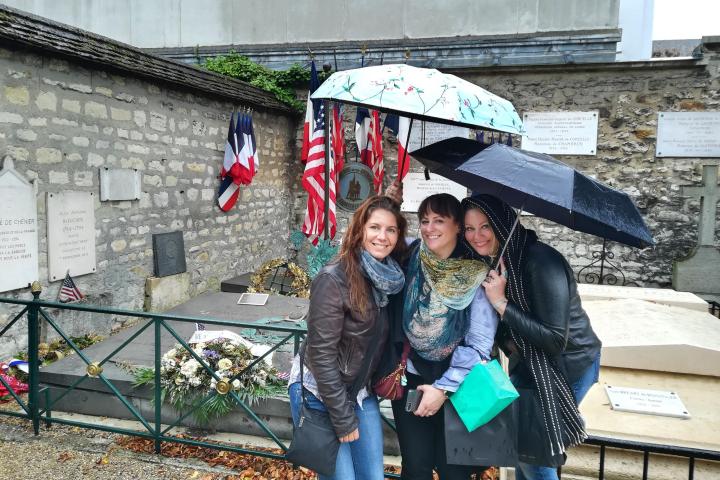 Three women posing in front of a memorial