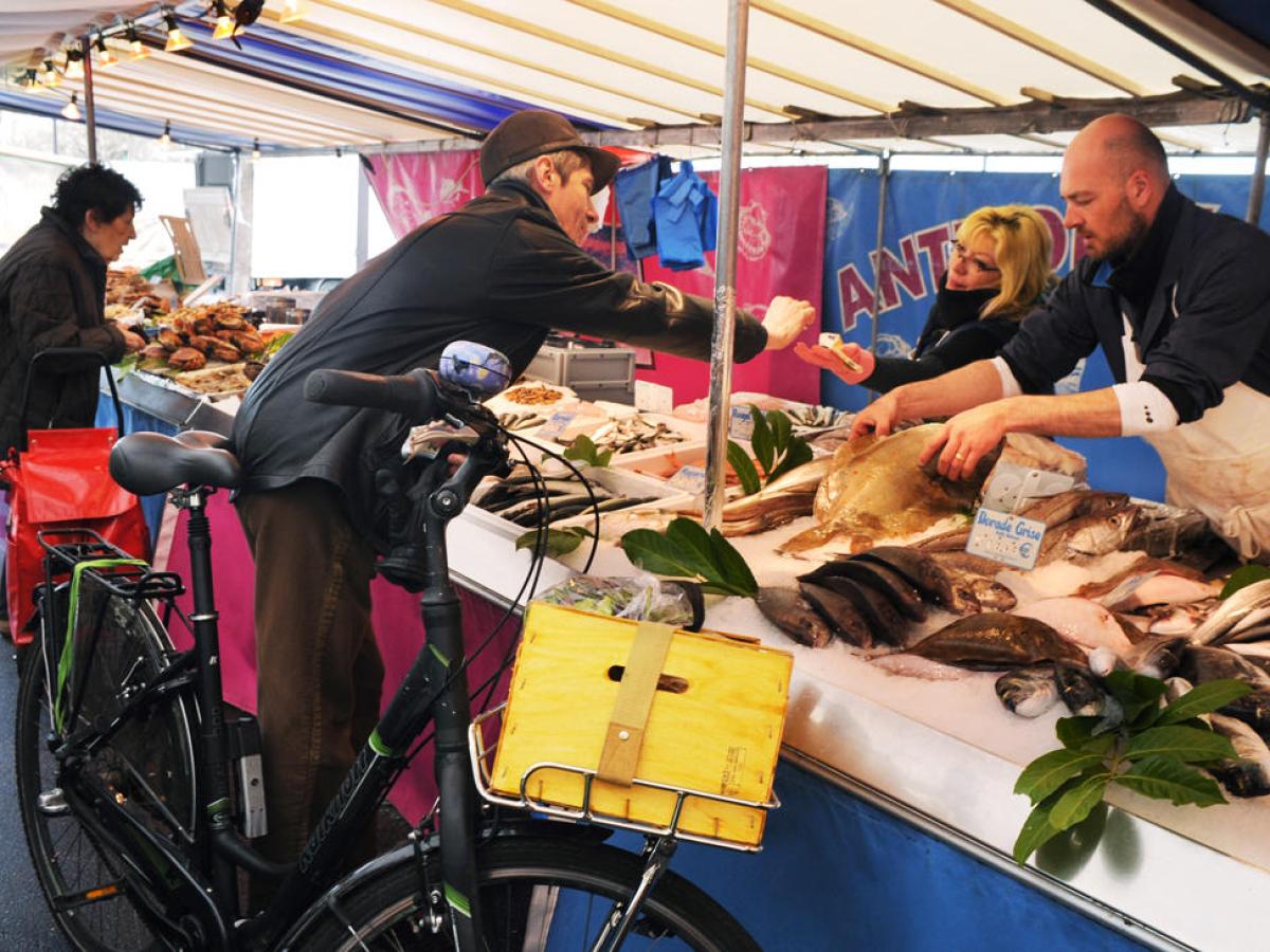 Man on bike purchasing produce