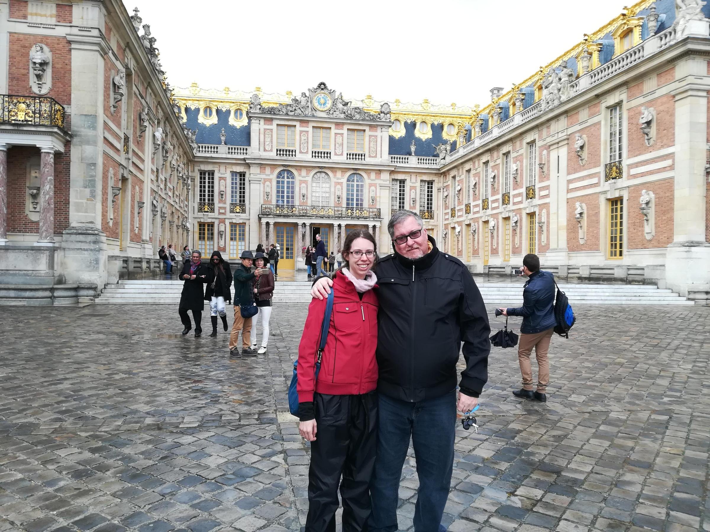 Man and woman posing for picture in courtyard