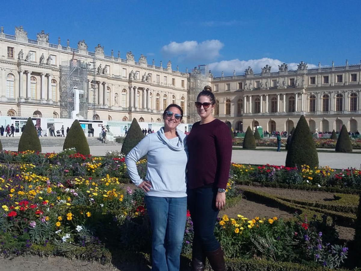 Two woman posing for a picture in front of castle