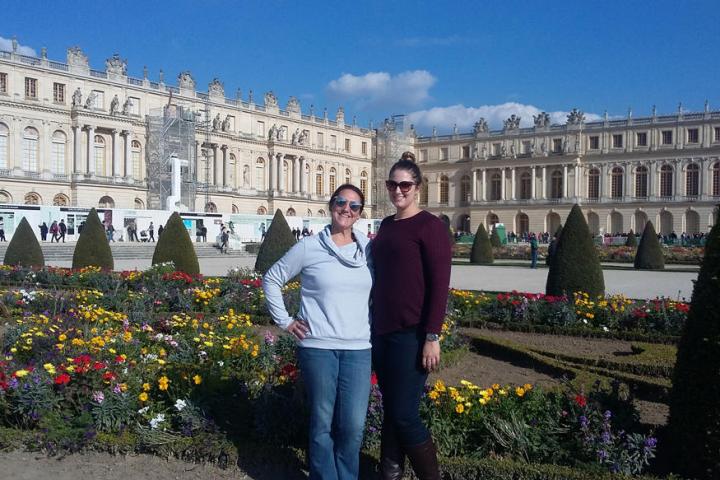 Two woman posing for a picture in front of castle