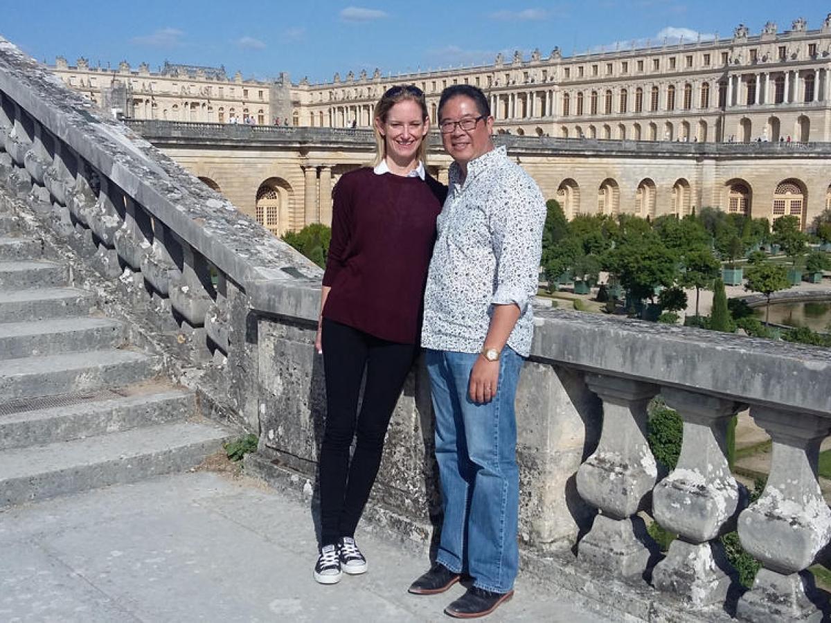 Man and woman posing for a picture near castle