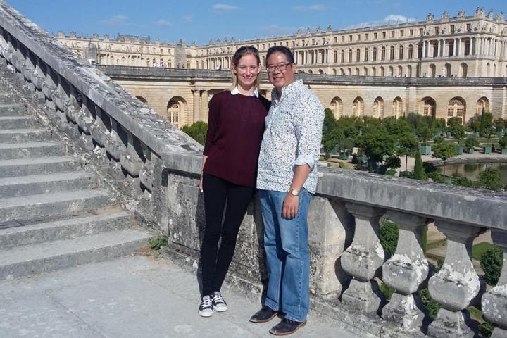 Man and woman posing for a picture near castle