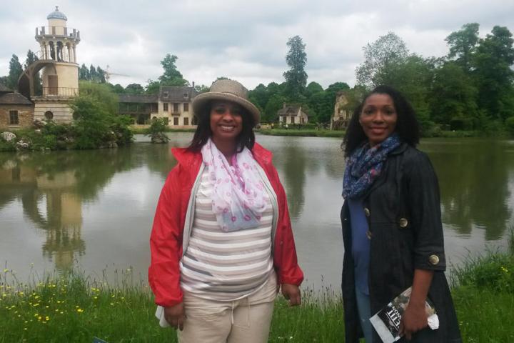 Two women standing next to a lake