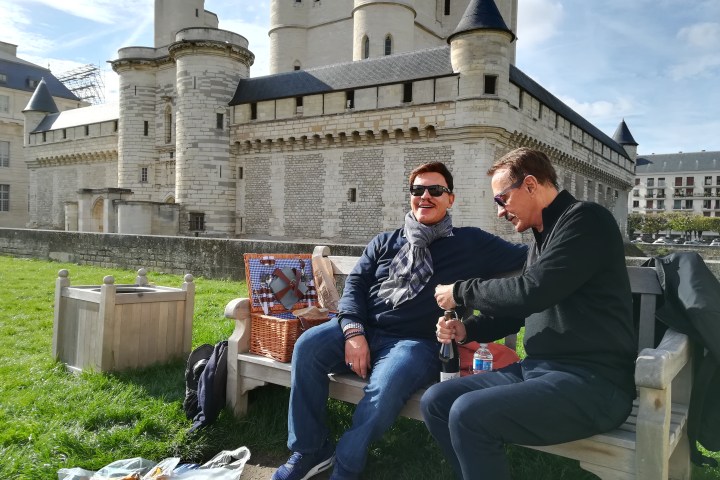 Couple sitting on a bench having a picnic